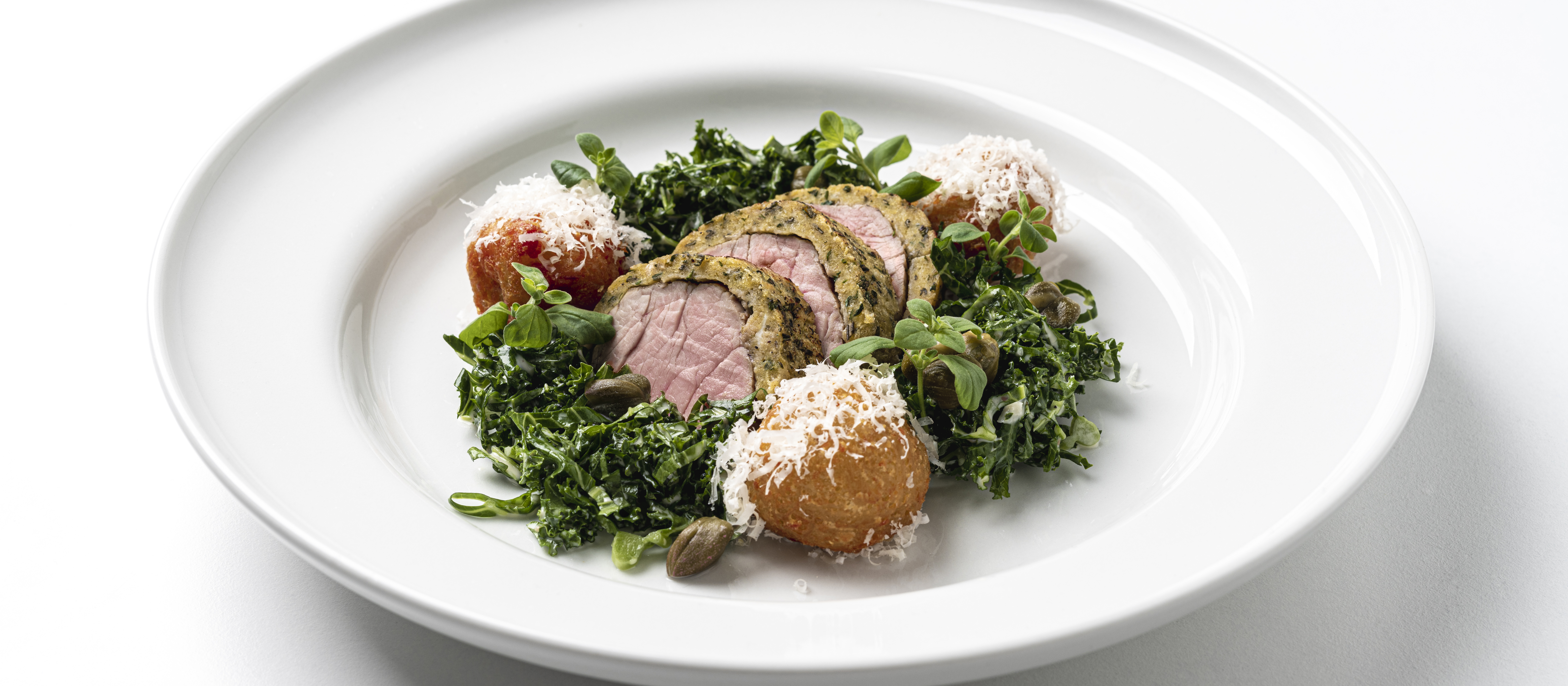 Yrttikuorrutettua possua, perunakroketteja ja lehtikaalicaesaria